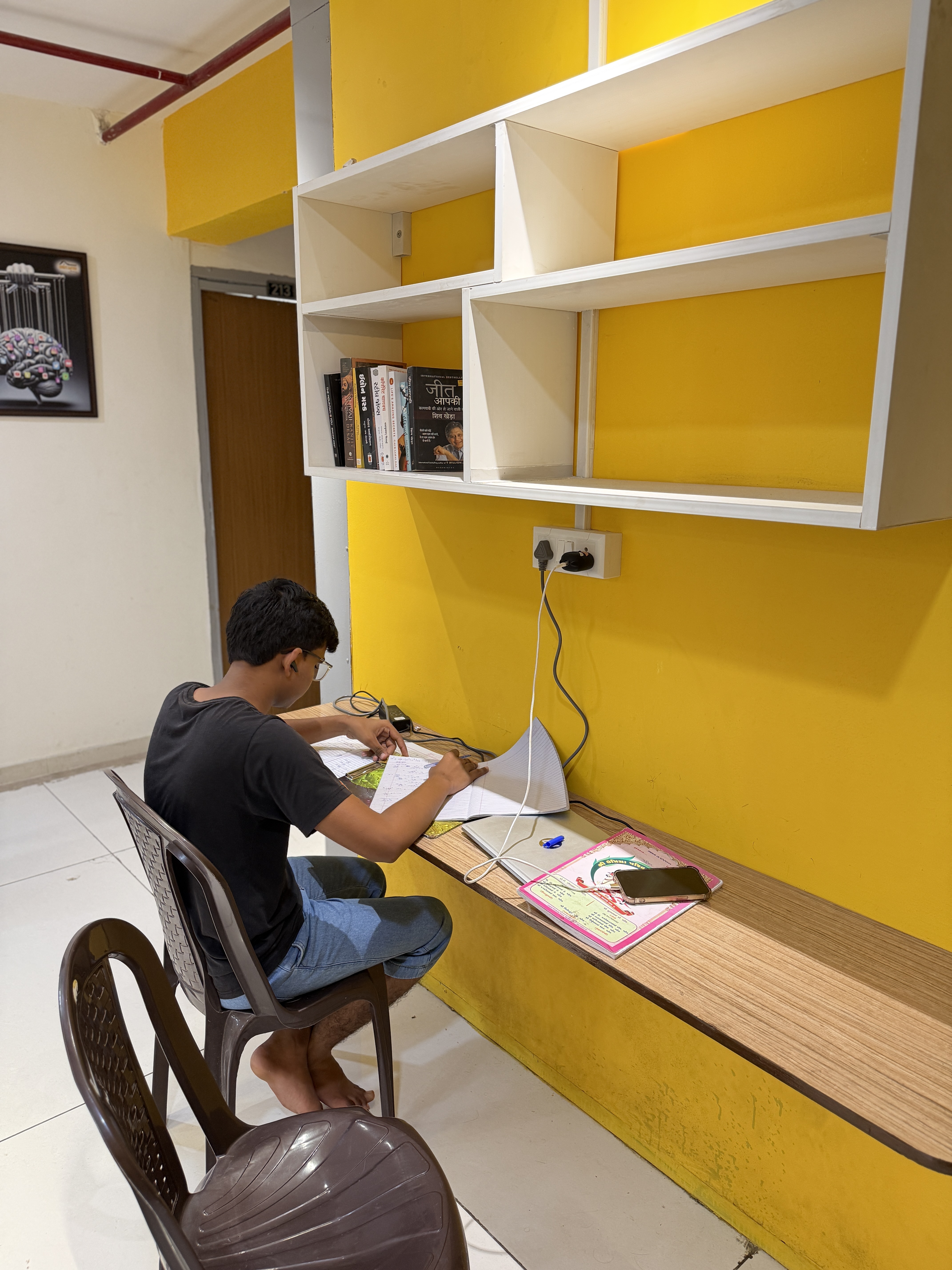Resident studying at the in-room study desk, Gurukul Road PG